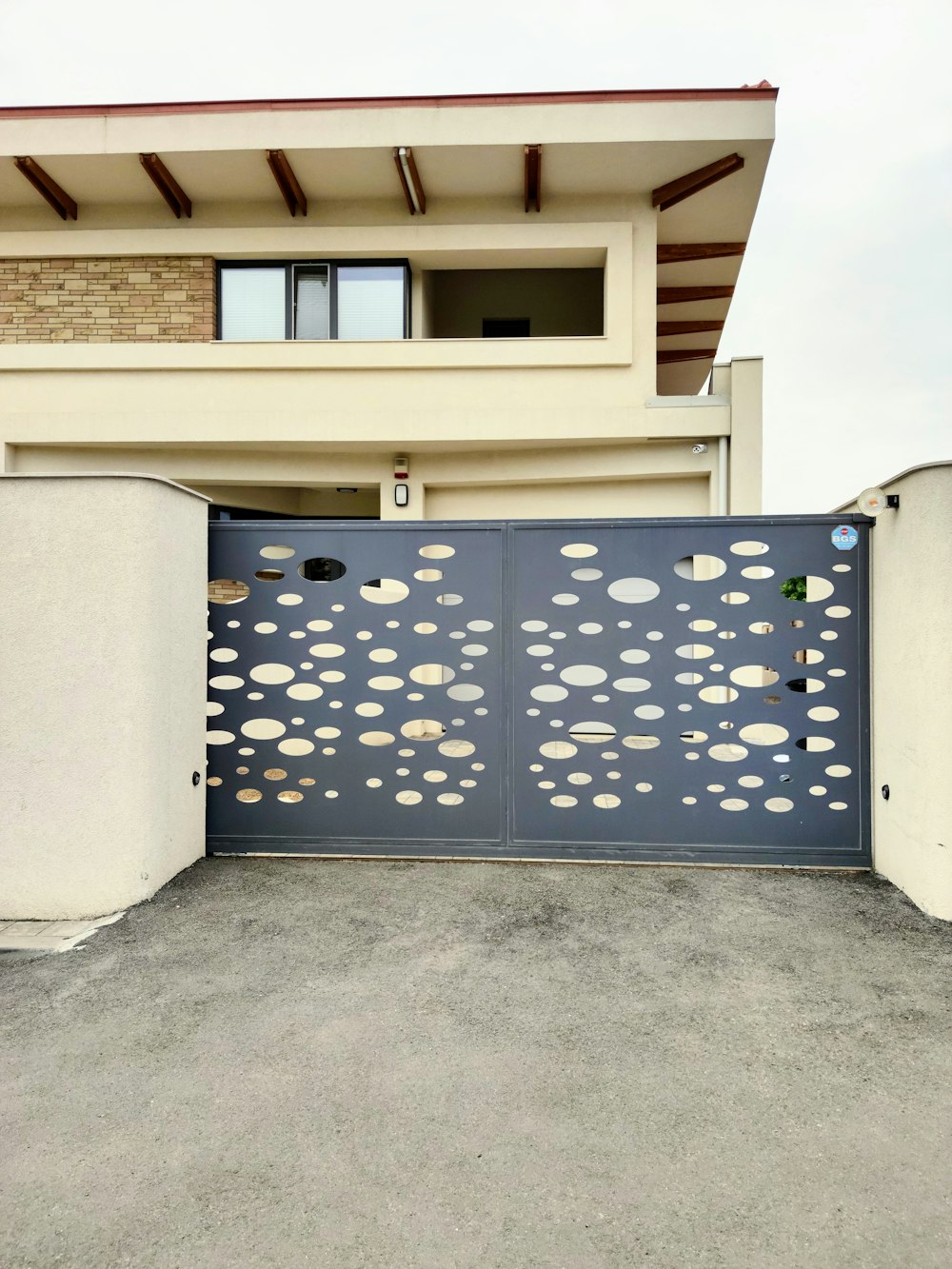 Portón corredizo metálico con diseño perforado en una casa de Talca